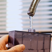 Image of Polar Cooling's water tank being filled under a faucet